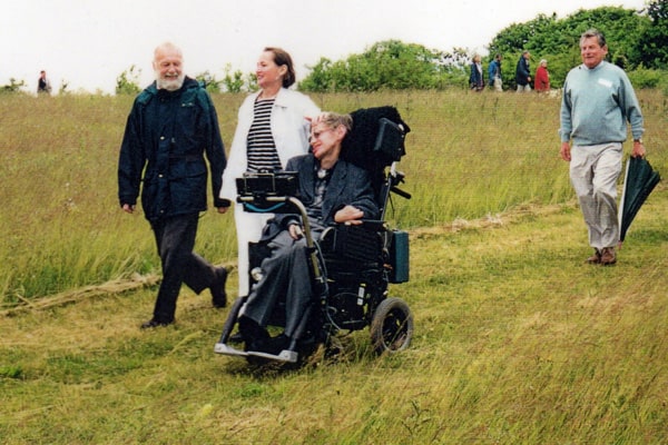 Pr0fessor Stephen Hawking (in wheelchair) and three others on easy access path after official opening of disabled access at Magog Down, 1995