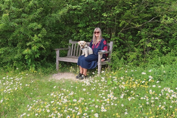Woman with small dog sitting on bench on North Down