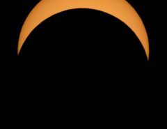 Partial solar eclipse, with moon moving across the sun