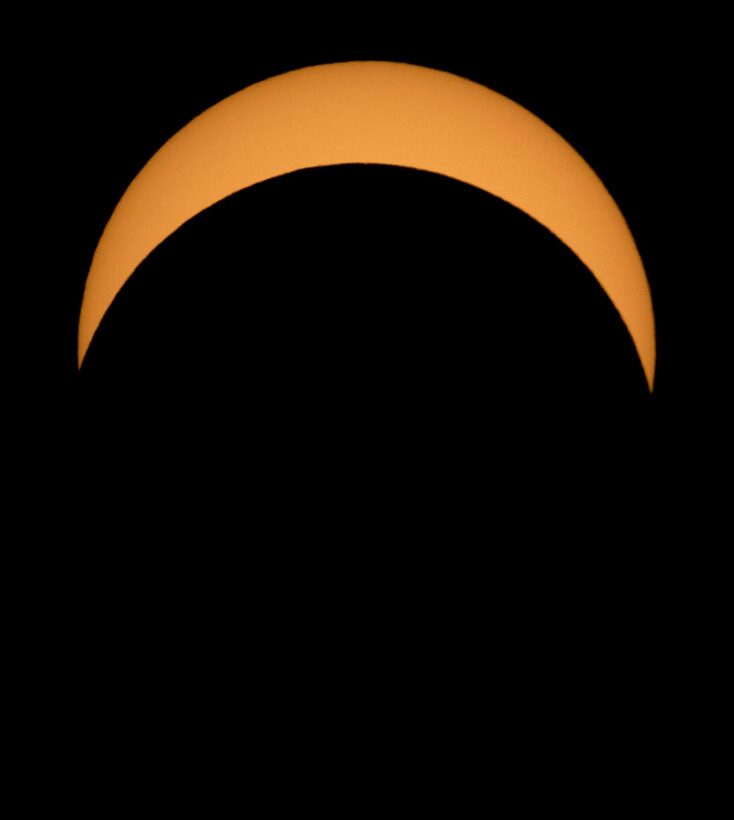 Partial solar eclipse, with moon moving across the sun